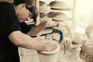 Katy West using the Jigger and Jolly machine at Highland Stoneware